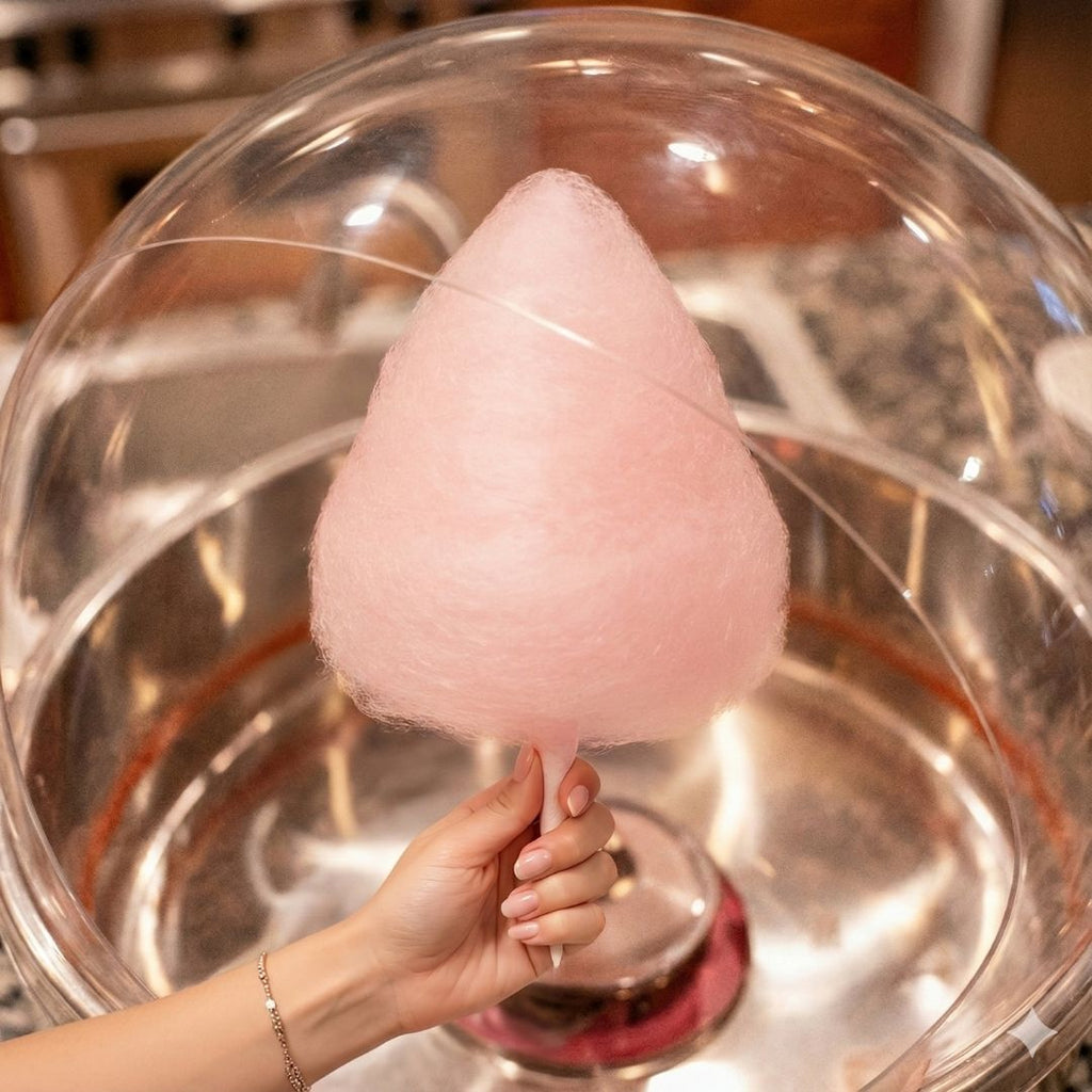 Watermelon cotton candy forming inside a cotton candy machine using Colorwayz naturally flavored and colored cotton candy sugar, soft pink dye-free floss candy close-up